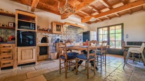 une salle à manger avec une table et des chaises en bois dans l'établissement Mas de la Plaine, à Marsillargues