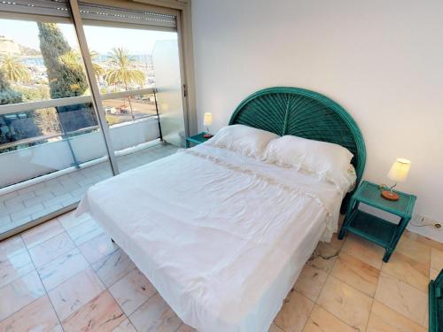 une chambre avec un grand lit et une grande fenêtre dans l'établissement Grand 2P avec Terrasse, Aperçu Mer et Garage Privé – Menton Garavan - FR-1-196-268, à Menton