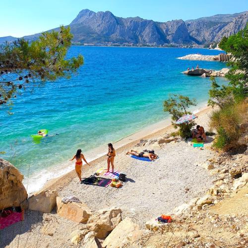 two girls are walking on a beach with the water at Apartments Mihael in Celina
