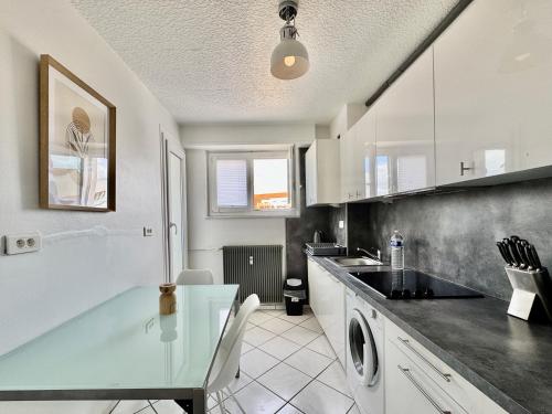 une cuisine avec un comptoir en verre et un lave-vaisselle dans l'établissement Bretzel, à Colmar