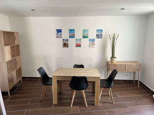 une salle à manger avec une table et des chaises en bois dans l'établissement Duplex Cosy en Cœur de Ville, à Lunel