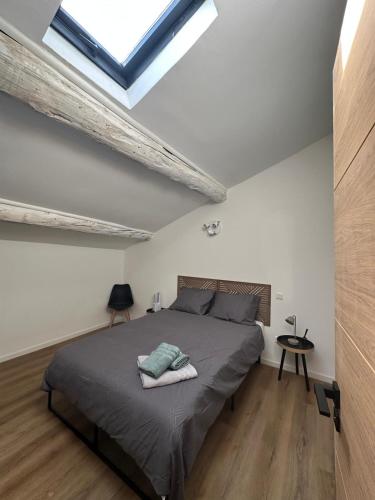 une chambre avec un lit et une lucarne dans l'établissement Duplex Cosy en Cœur de Ville, à Lunel