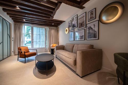 un salon avec un canapé et une table dans l'établissement Luxury 2BR - Place des Vosges - Le Marais, à Paris