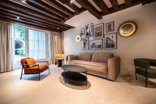 un salon avec un canapé, une table et des chaises dans l'établissement Luxury 2BR - Place des Vosges - Le Marais, à Paris