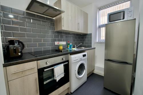 a kitchen with a washing machine and a washer at Gosford Park Studio 2 - Coventry in Coventry