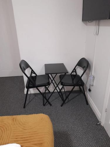 two chairs and a table in a room at Gosford Park Studio 2 - Coventry in Coventry