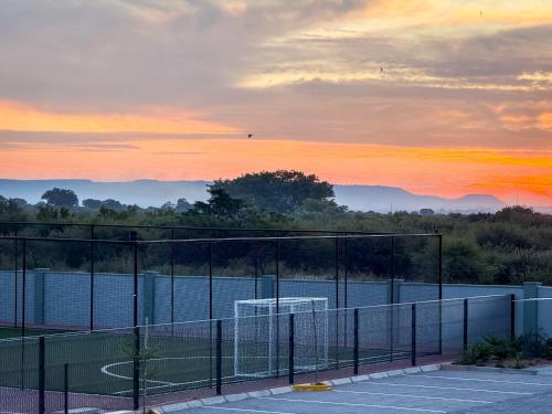 a view of a tennis court at sunset at LLL Apartments in Gaborone