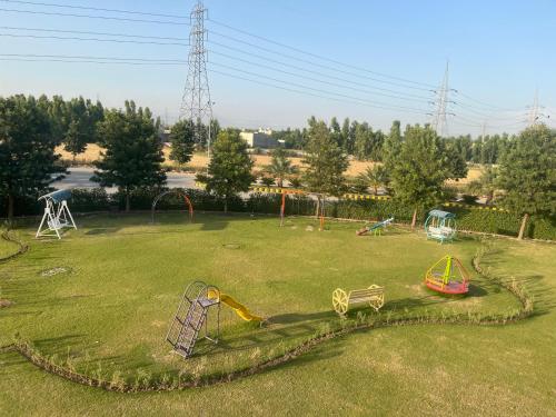 a park with a bunch of playground equipment in the grass at Alhamra Hotel in Mardan