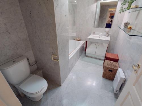 une salle de bain blanche avec des toilettes et un lavabo dans l'établissement Grand 2P face mer avec balcon, parking, piscine et spa en centre-ville à Menton - FR-1-196-284, à Menton