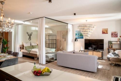 a living room with a white couch and a bed at Danube Rooms - Self Checkin - Küche in Passau