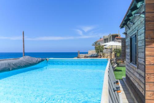 ein Swimmingpool mit dem Meer im Hintergrund in der Unterkunft Sea Lofts - Kfar Abida Oceanfront Retreats in Ad Diqār