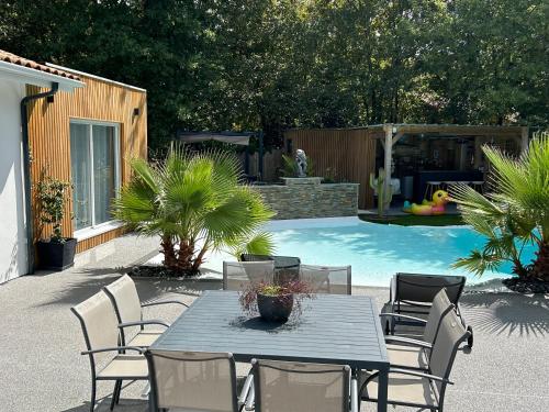 a patio with a table and chairs next to a pool at Little Paradise in Belin-Beliet