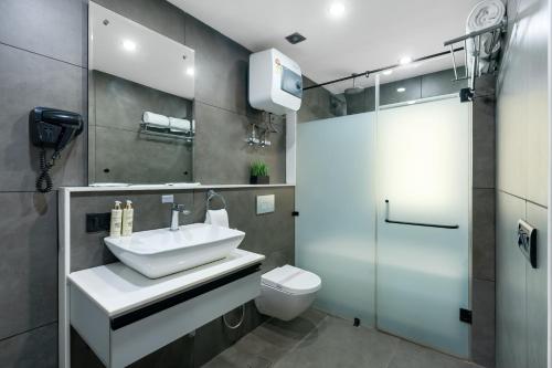 a bathroom with a sink and a toilet and a shower at BedChambers Serviced Apartments - Cyber City in Gurgaon