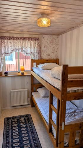 Un dormitorio con dos literas y una ventana. en Stor älg, en Dalskog