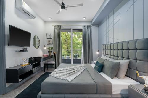 a bedroom with a large bed and a desk at BedChambers Serviced Apartments - Cyber City in Gurgaon