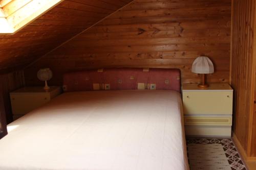 a bedroom with a bed in a wooden attic at Apartments Paula in Splitska