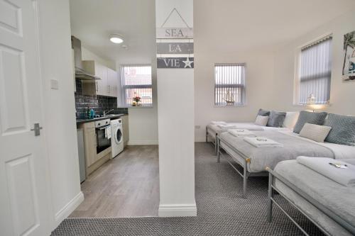 a living room with two beds and a kitchen at Gosford Park Studio 4 - Coventry in Coventry