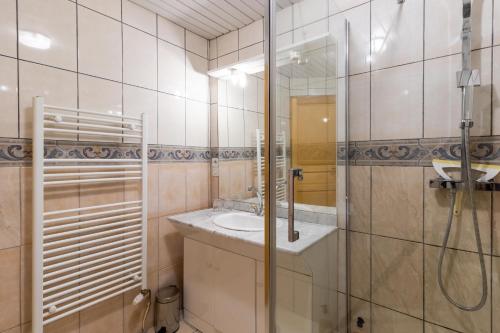 a bathroom with a sink and a glass shower at Chambre Millepertuis in Auriac-du-Périgord