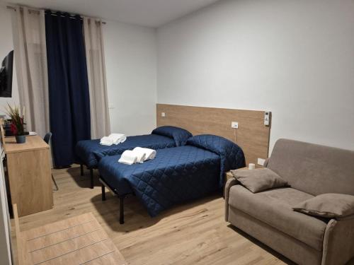 a bedroom with a blue bed and a couch at B&B La Dimora in Gissi