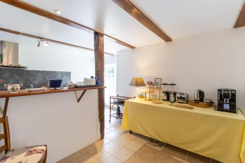 une cuisine avec une table jaune dans une pièce dans l'établissement Chambre Millepertuis, à Auriac-du-Périgord