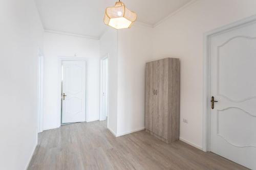 Habitación vacía con paredes blancas y puerta de madera. en Villetta Teresa - Salento Reservation, en Capilungo