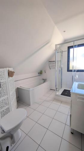 une salle de bain blanche avec une baignoire et un lavabo dans l'établissement L'Estran, Maison 6-7 personnes, Terrasse et Jardin, à Villers-sur-Mer