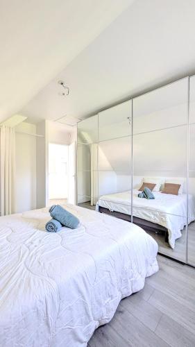 une chambre avec deux lits et un grand miroir dans l'établissement L'Estran, Maison 6-7 personnes, Terrasse et Jardin, à Villers-sur-Mer