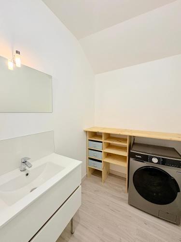 une cuisine blanche avec un évier et une machine à laver dans l'établissement Hypercentre - 3 chambres - proche château et commerces, à Châteaubriant
