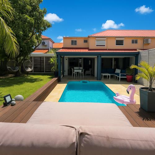 a swimming pool with a pink flamingo in a backyard at Villa Tropiraizet in Les Abymes