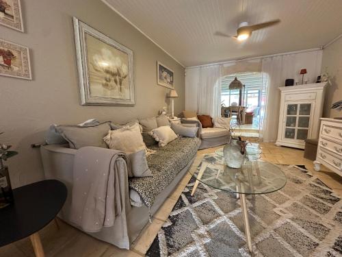 a living room with a couch and a glass table at Villa Tropiraizet in Les Abymes