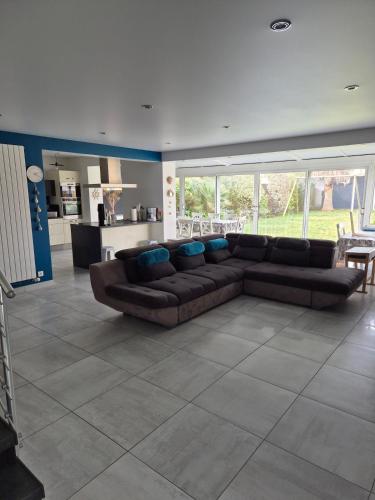 un salon avec un canapé marron et une cuisine dans l'établissement Très belle maison de famille à 5 min de la plage, au Croisic