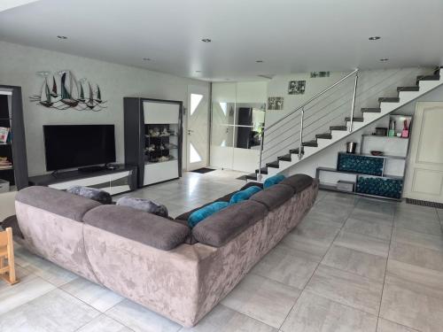 a living room with a couch and a staircase at Très belle maison de famille à 5 min de la plage in Le Croisic