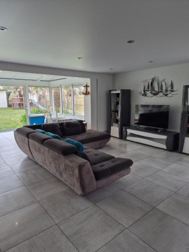 Il comprend un grand salon avec des canapés et une télévision à écran plat. dans l'établissement Très belle maison de famille à 5 min de la plage, au Croisic