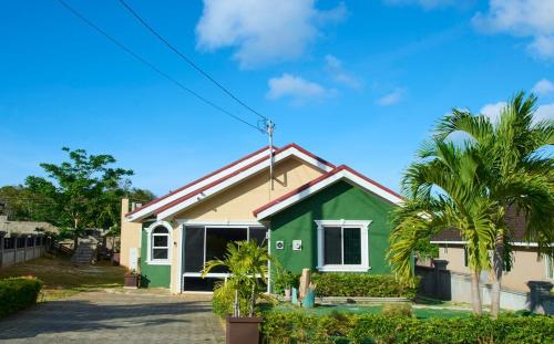 a woman sitting in front of a house at Dejean serenity in Ocho Rios