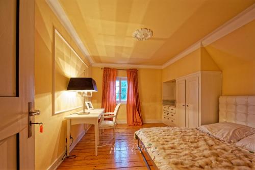 a bedroom with a bed and a desk and a table at Villa Philipp Plein - Designervilla mit Pool in Amriswil