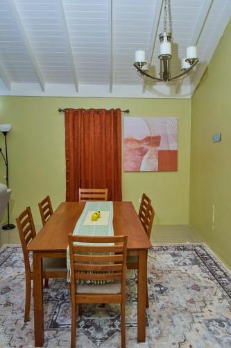 a dining room with a wooden table and chairs at Dejean serenity in Ocho Rios