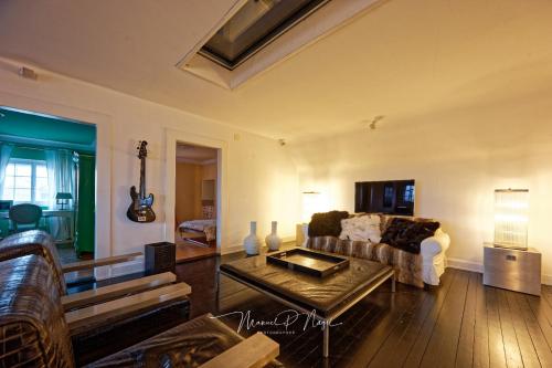 a living room with a couch and a table at Villa Philipp Plein - Designervilla mit Pool in Amriswil