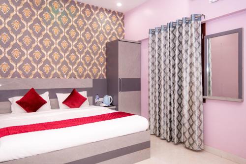 a bedroom with a bed with red pillows and a window at Hotel Ayodhya Palace - 400 Mtrs from HANUMAN GARHI in Ayodhya