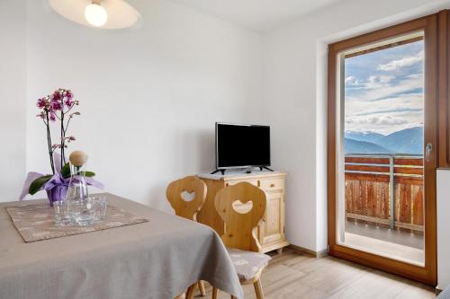 Un comedor con una mesa con una computadora portátil encima. en Forchnerhof Apt Ploseblick, en Maranza