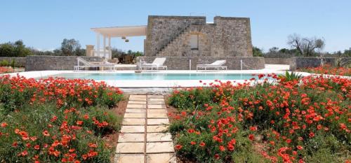 una piscina en un jardín con flores en Villa Virò by salentoltremare, en Alessano