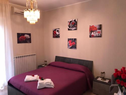a bedroom with a bed and pictures on the wall at Residenza delle Rose in Lamezia Terme