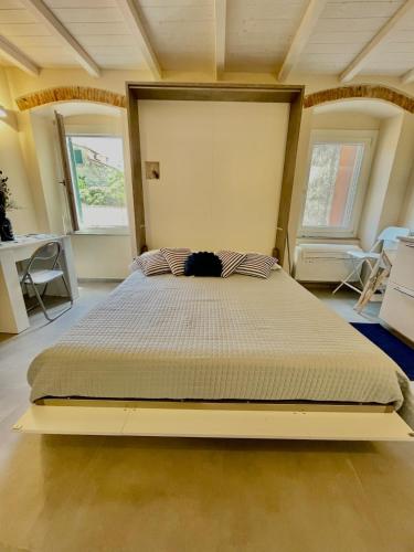a large bed in a room with two windows at La Gritta in Lerici