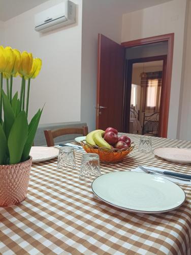 a table with a bowl of fruit on a checkered table cloth at Da Adry e Lodo in Settimo San Pietro