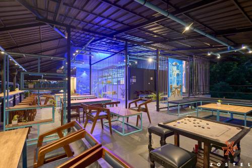 a restaurant with tables and a board game at Zostel Varkala in Varkala
