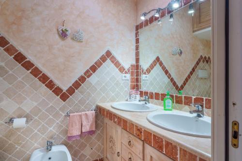 a bathroom with two sinks and a mirror at La Terrazza sul mare in Palau