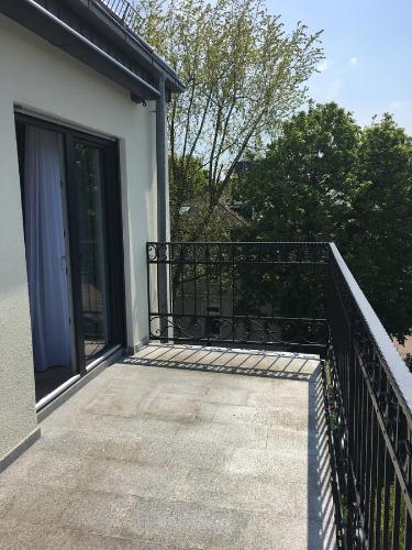 a balcony with a black railing and a door at Merkel Villa Apartamente in Wiesbaden