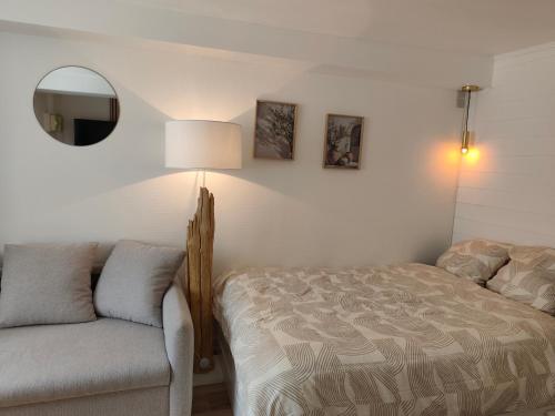 une chambre avec un lit, une chaise et un miroir dans l'établissement Appartement élégant, chaleureux et cosy à Reims, à Reims