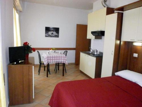 a room with a table and a kitchen with a table and chairs at Residence Carioca in Rimini