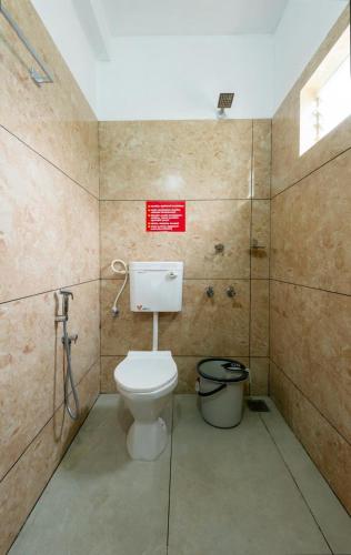 a bathroom with a toilet and a sign on the wall at Max residency in Kozhikode