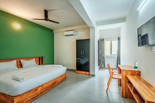 a bedroom with a bed and a table and a desk at Max residency in Kozhikode